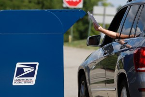 A person deposits mail in a box outside United States Post Office in Cranberry Township, Pa., Wednesday, Aug. 19, 2020. (AP Photo/Gene J. Puskar)