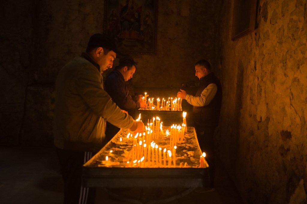 Worshippers light candles at the Dadivank Monastery​, which lies in territory now ceded to Azerbaijan.