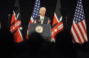 Joe Biden makes a speech in Kenya in front of American and Kenyan flags.