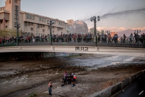 Un joven de 16 años es atendido por personal de rescate en el lecho del río Mapocho luego de que un policía lo empujara del puente durante las protestas.