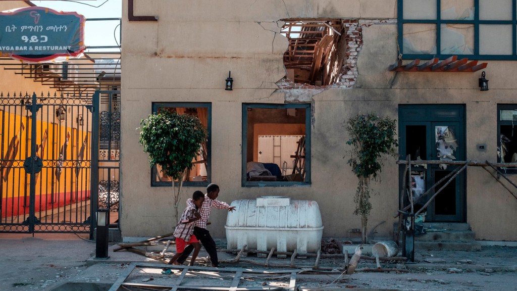 Children play in front of a hotel damaged by mortar shelling, in Humera, Ethiopia.