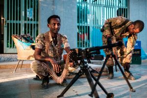 A member of the Amhara Special Forces sits next to a machine gun at an improvised camp in the front of a shop in Humera, Ethiopia.