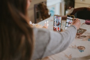 Young woman celebrating birthday in home isolation with her friends on video chat