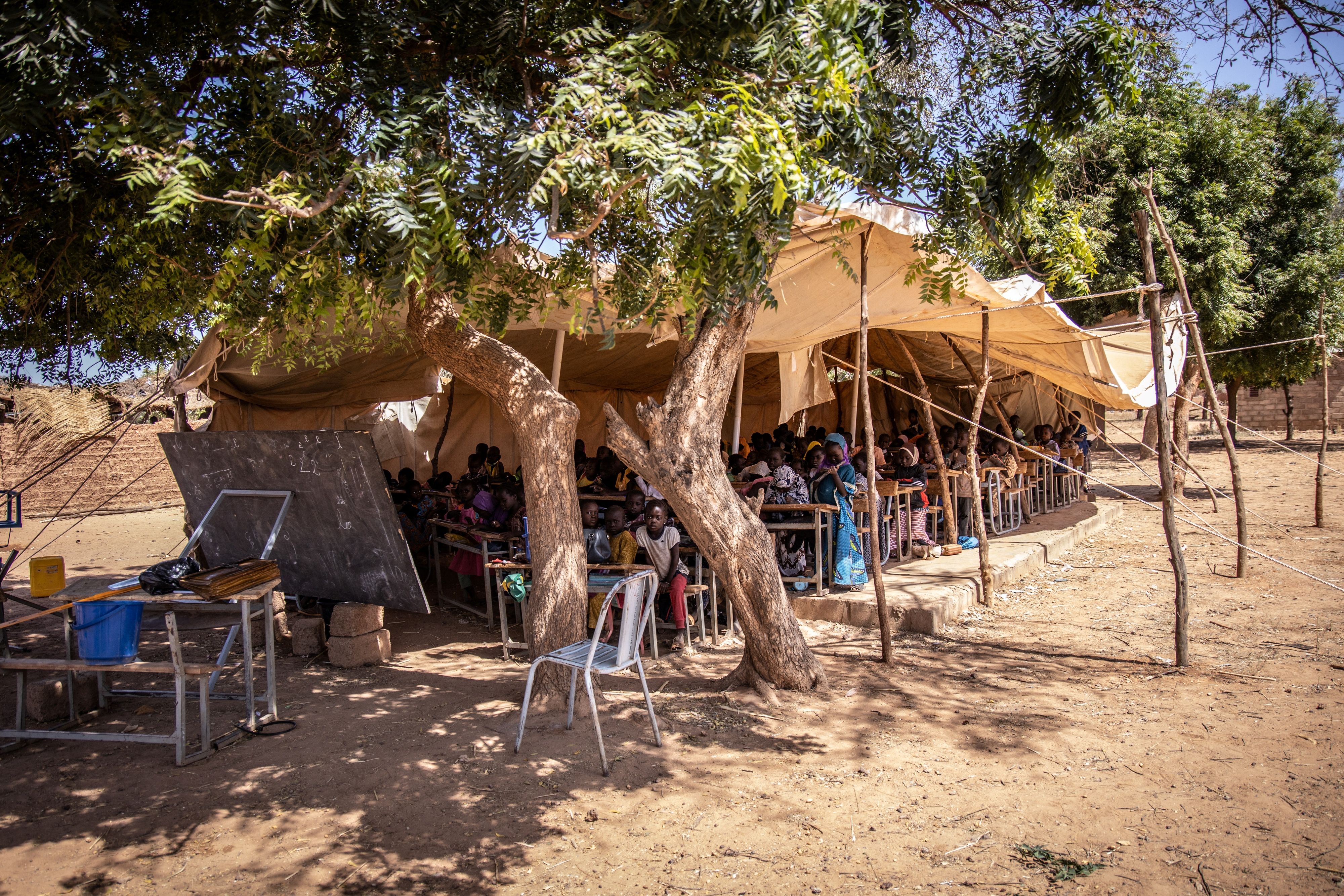 Students study in a tent under a tree in Burkina Faso.