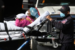 A woman lying on a stretcher is wheeled out of Wyckoff Heights Medical Center in the Queens borough of New York City, NY, November 10, 2020. (Anthony Behar/Sipa USA)(Sipa via AP Images)​