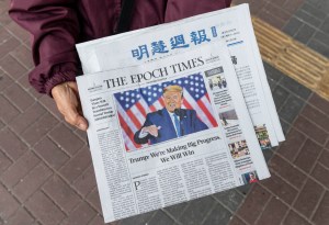 A woman distributes the multi-language newspapers The Epoch Times newspaper  in Hong Kong. (Photo by Miguel Candela / SOPA Images/Sipa USA)(Sipa via AP Images)​