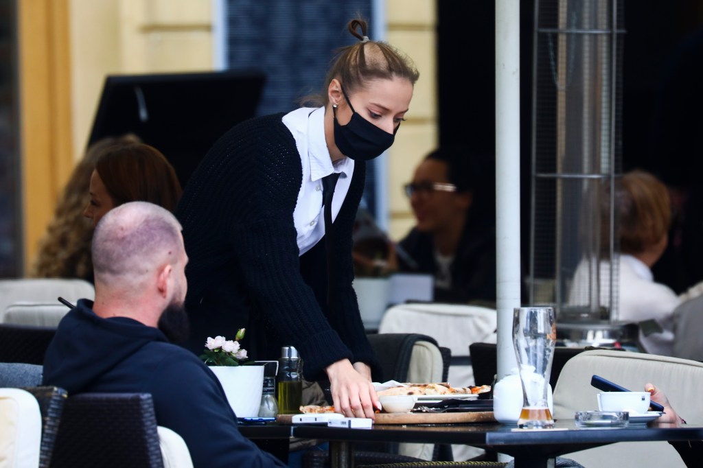 A waitress is wearing a protective face mask during coronavirus pandemic. Krakow, Poland on October 9, 2020.