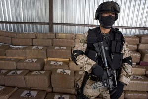 A Mexican soldier stands guard next to packages of marijuana found at a warehouse in Tijuana, Mexico