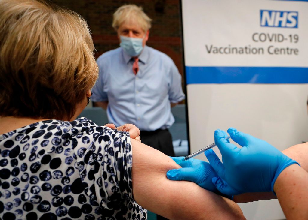 Britain's Prime Minister Boris Johnson watches as nurse Rebecca Cathersides administers the Pfizer-BioNTech COVID-19 vaccine to Lyn Wheeler at Guy's Hospital in London, on December 8, 2020. Photo: Frank Augstein / POOL / AFP