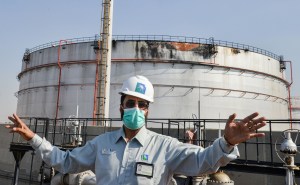 A Saudi Aramco employee gestures while standing near a missile-damaged silo, at the plant in Jeddah last month. Photo: FAYEZ NURELDINE/AFP via Getty Images