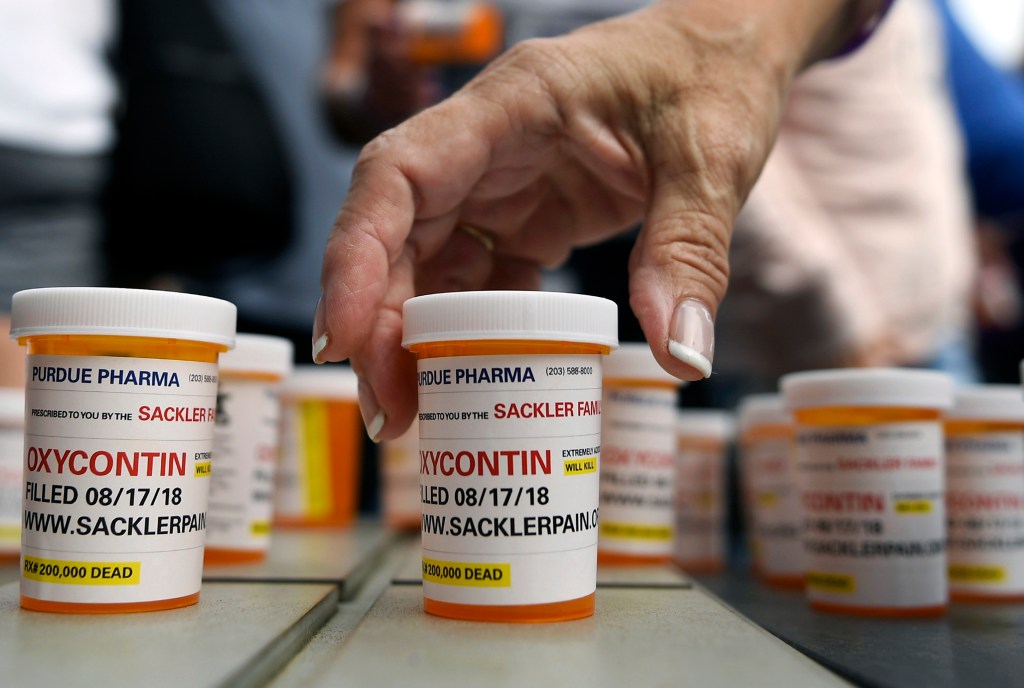 In this Aug. 17, 2018, file photo, family and friends who have lost loved ones to OxyContin and opioid overdoses leave pill bottles in protest outside the headquarters of Purdue Pharma, which is owned by the Sackler family, in Stamford, Conn.