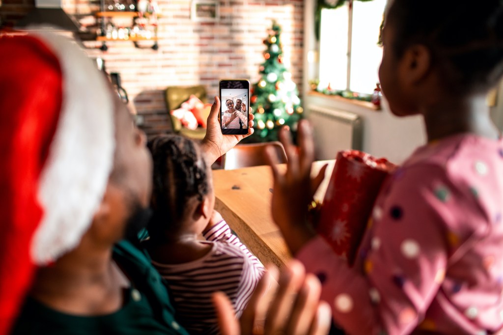 Close up of a young family on a video call with their grandparents