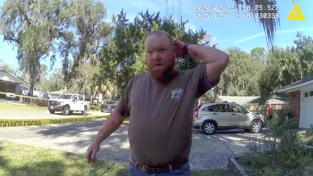 In this Feb. 23, 2020 image taken from Glynn, Ga., County Police body camera video, Travis McMichael speaks to a police officer at the scene where Ahmaud Arbery, a 25-year-old Black man, was shot and killed while while running in a neighborhood outside th