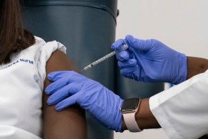 Sandra Lindsay, left, a nurse at Long Island Jewish Medical Center, is inoculated with the Pfizer-BioNTech COVID-19 vaccine by Dr. Michelle Chester, Monday, Dec. 14, 2020, in the Queens borough of New York.