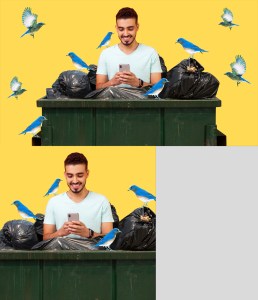 A man looking at his phone in a dumpster