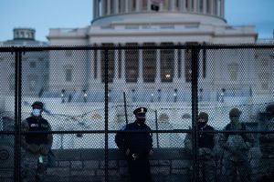 A Capitol Police officer stands with members of the National Guard behind a crowd control fence surrounding Capitol Hill. Photo: BRENDAN SMIALOWSKI/AFP via Getty Images