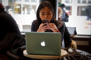 Woman looking at laptop and phone