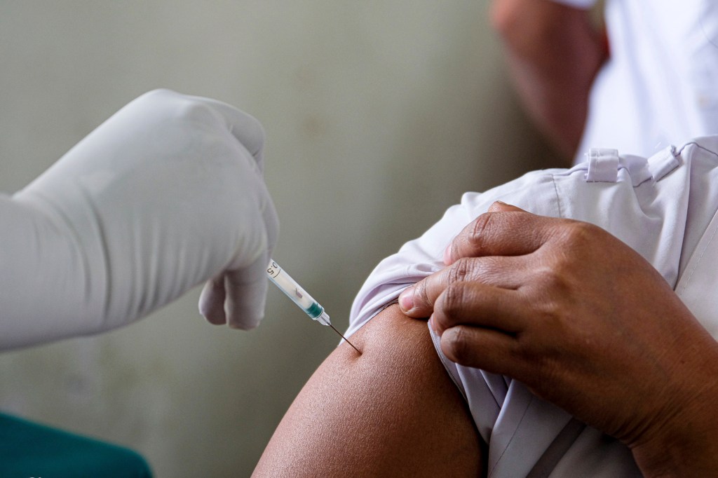 A vaccination volunteer is vaccinating a frontline worker during COVID-19 vaccine dry run. COVID-19 vaccine dry run is happening in all over west Bengal with three sites in Kolkata, 69 in West Bengal.