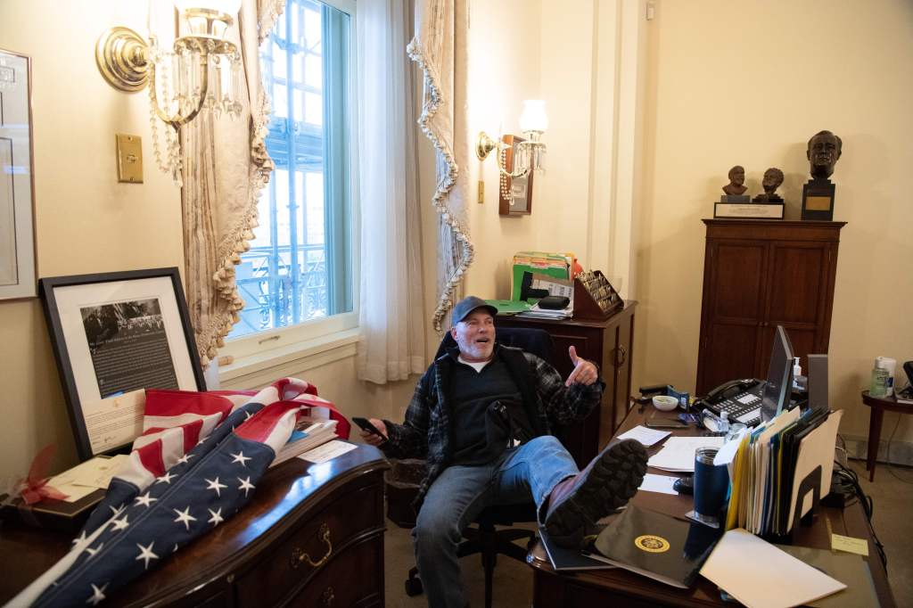 Richard Barnett, a supporter of US President Donald Trump sits inside the office of US Speaker of the House Nancy Pelosi as he protest inside the US Capitol in Washington, DC, January 6, 2021. - Demonstrators breeched security and entered the Capitol as C