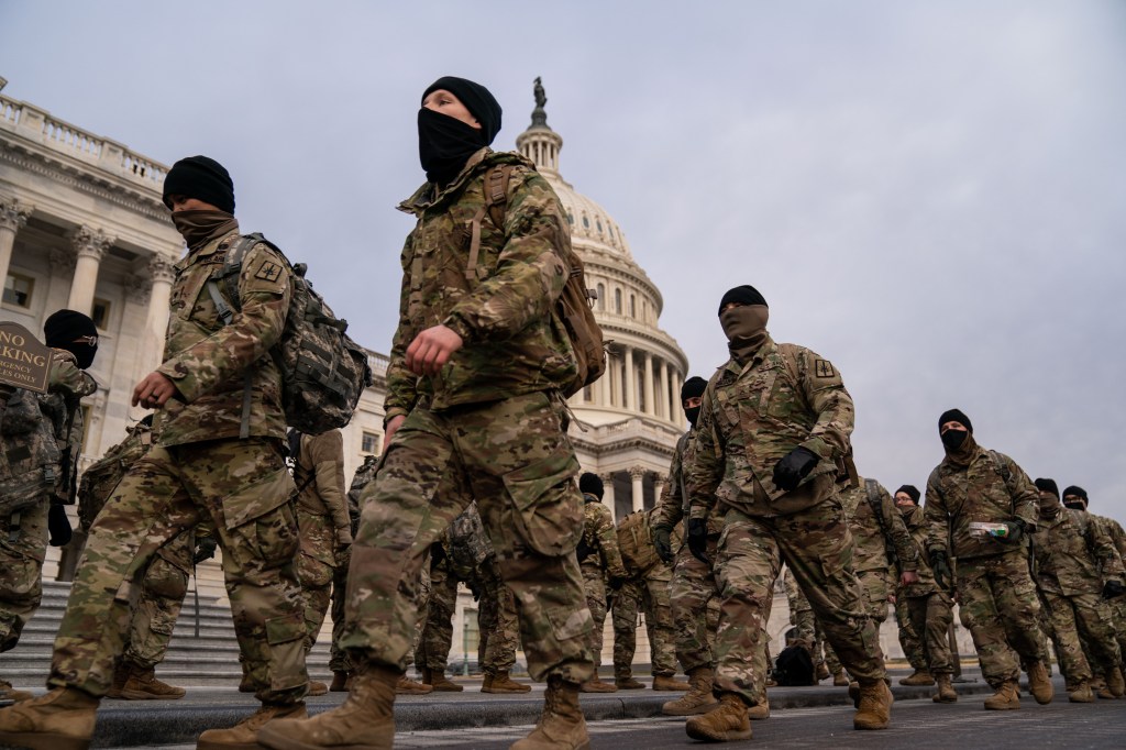 Members of the National Guard walk in front of the U.S. Capitol