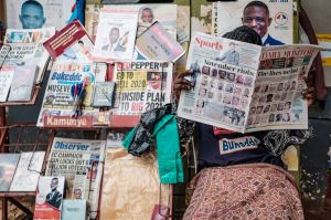 A man reads newspapers reporting about Uganda's upcoming elections at a kiosk in Kampala.