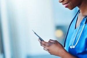 A healthcare worker smiling at their phone.