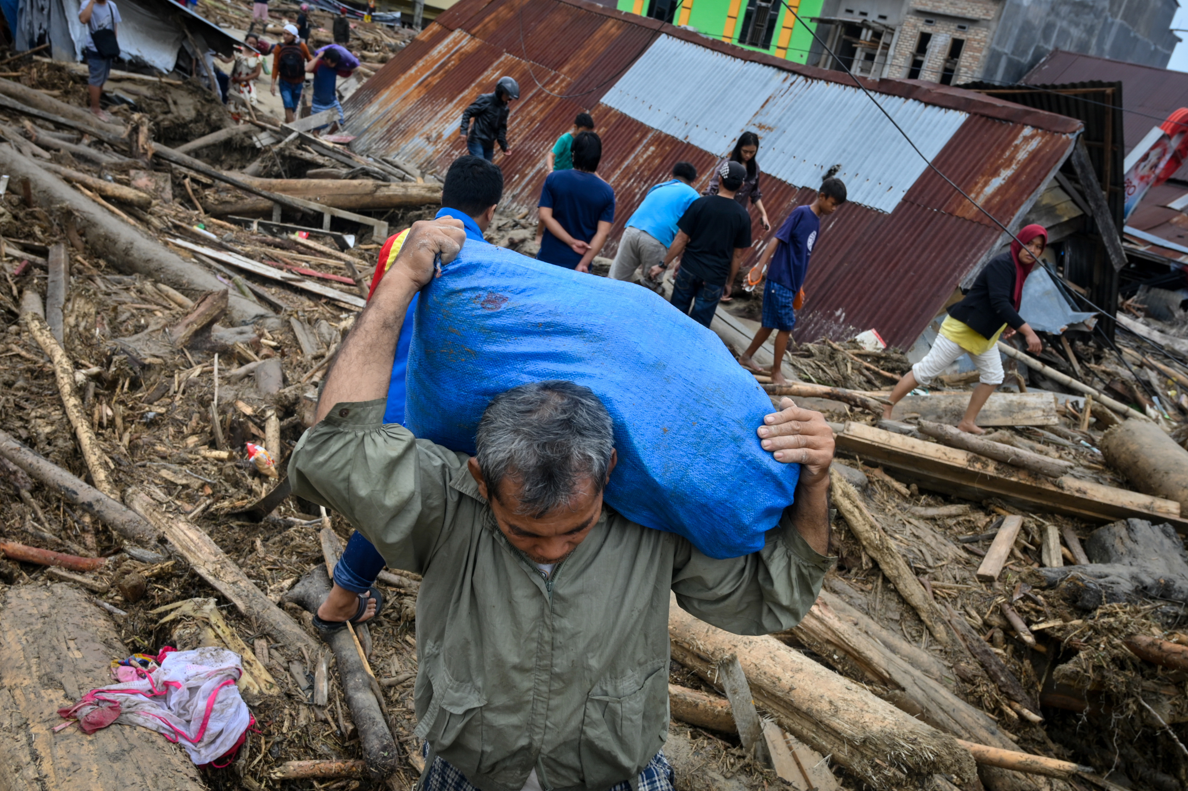 Villagers evacuate their homes following flash floods in South Sulawesi. (PHOTO: AFP / Hariandi HAFID)