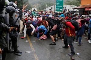 Los migrantes rompen una barricada policial cuando intentan ingresar a Guatemala en el puesto de control fronterizo el 16 de enero de 2021 en El Florido, Guatemala.