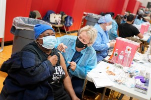 Mary Jenkins, left, received the COVID-19 vaccine in Paterson, N.J., Thursday, Jan. 21, 2021. The first people arrived around 2:30 a.m. for the chance to be vaccinated at one of the few sites that does not require an appointment.