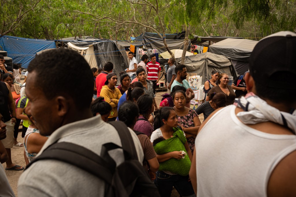 Asylum seekers stand for a headcount at a makeshift migrant camp in Matamoros, Tamaulipas state