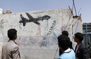 A Yemeni man looks at graffiti protesting against US drone strikes in Sana'a, Yemen