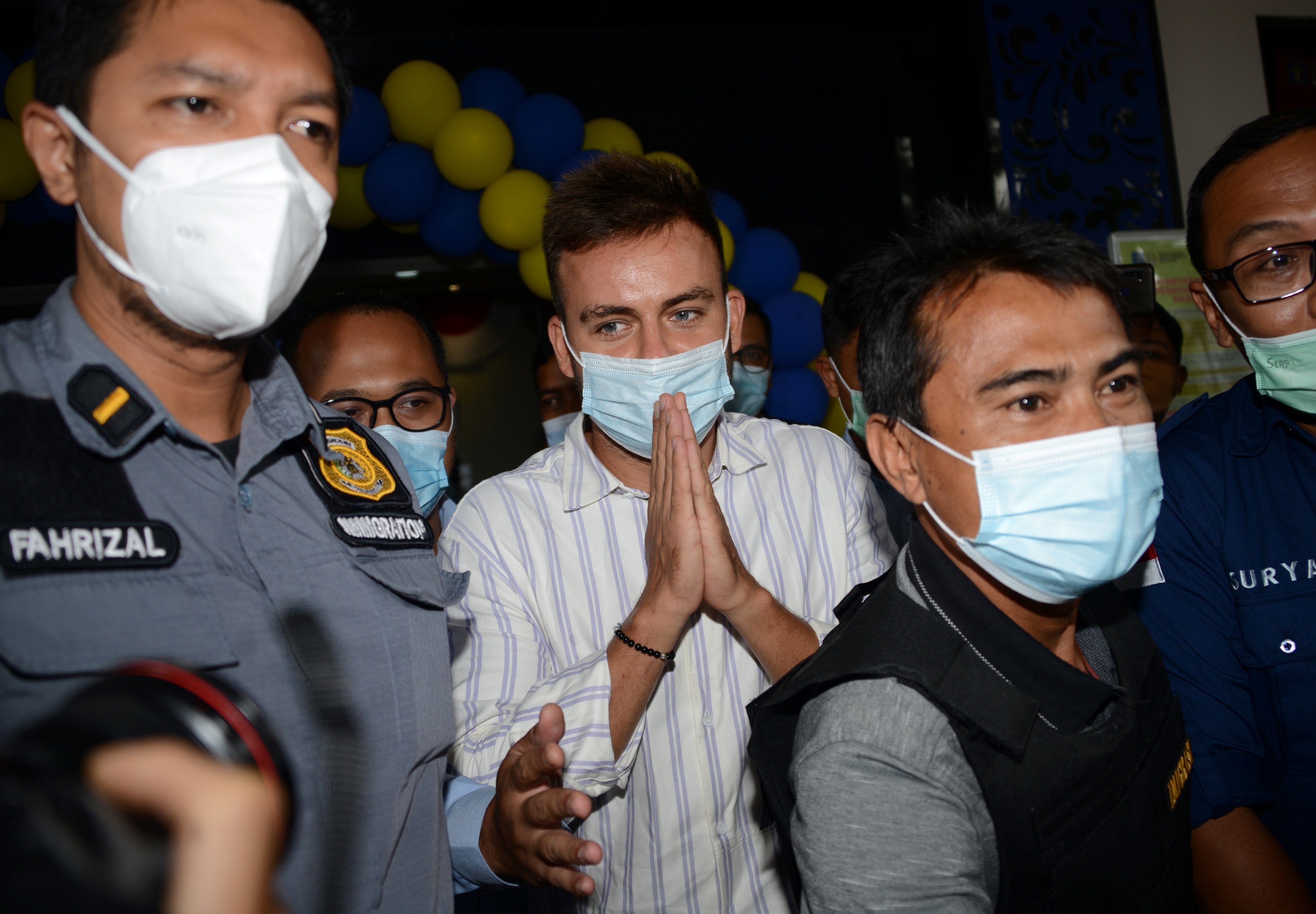 Russian national Sergey Kosenko is escorted by Indonesian immigration officials to Bali's Ngurah Rai Airport (PHOTO: AFP / SONNY TUMBELAKA)