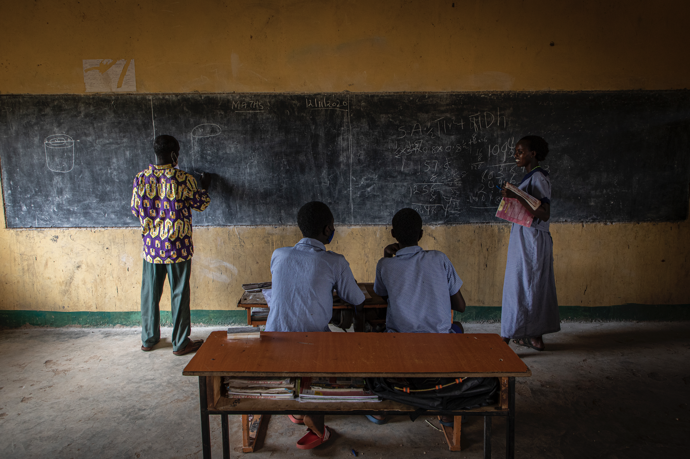 Students and teachers sit in a classroom.