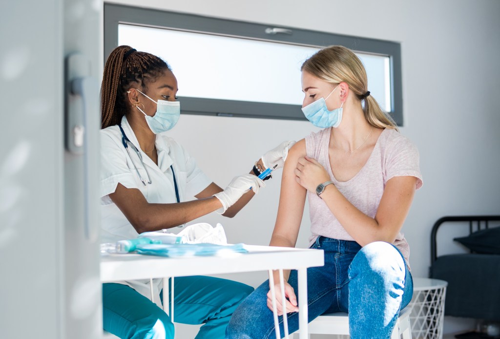 Woman with face mask getting vaccinated for coronavirus.