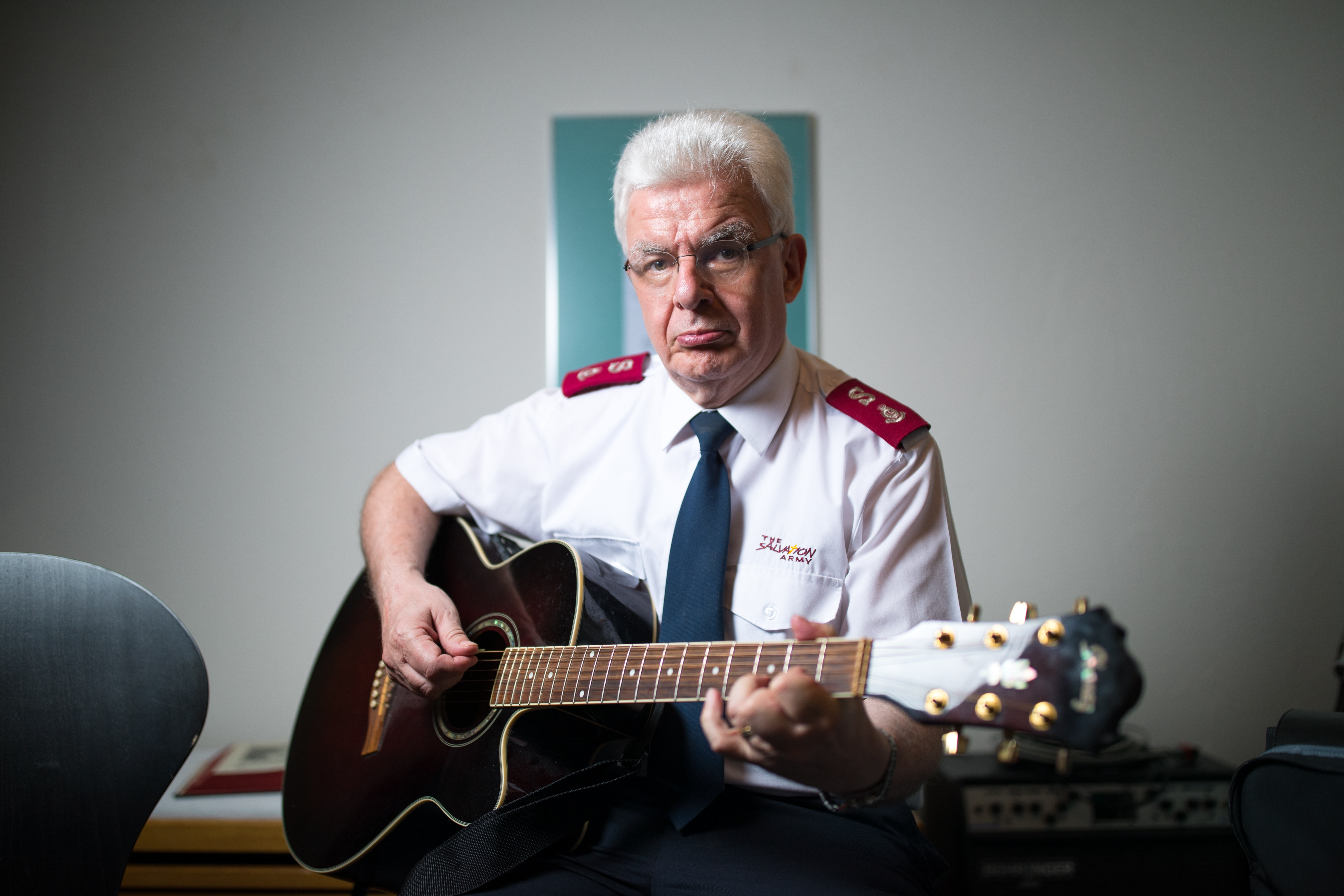 Beat Schulthess, wearing a white Salvation Army uniform and playing guitar.