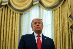 President Donald Trump listens during a ceremony to present the Presidential Medal of Freedom to former football coach Lou Holtz, in the Oval Office of the White House, Thursday, Dec. 3, 2020, in Washington.