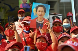 Migran Myanmar mengangkat foto Aung San Suu Kyi saat demo memprotes penangkapannya di depan Kedutaan Besar Myanmar di Bangkok pada 1 Februari 2021. Foto: LILLIAN SUWANRUMPHA / AFP