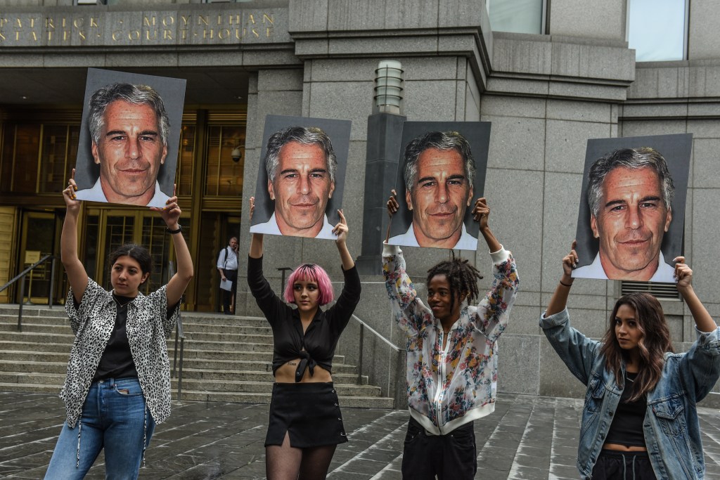 A protest group called "Hot Mess" hold up signs of Jeffrey Epstein in front of the Federal courthouse on July 8, 2019 in New York City.