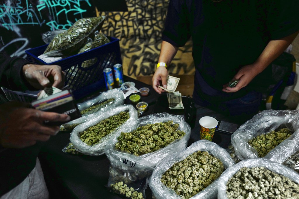 In this April 15, 2019, file photo, a vendor makes change for a marijuana customer at a cannabis marketplace in Los Angeles. (AP Photo/Richard Vogel, File)​