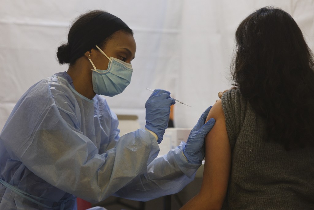 A healthcare worker administers the Pfizer BioNTech Covid-19 vaccine at a vaccination site inside a church in the Bronx borough of New York, U.S., on Friday, Feb. 5, 2021.