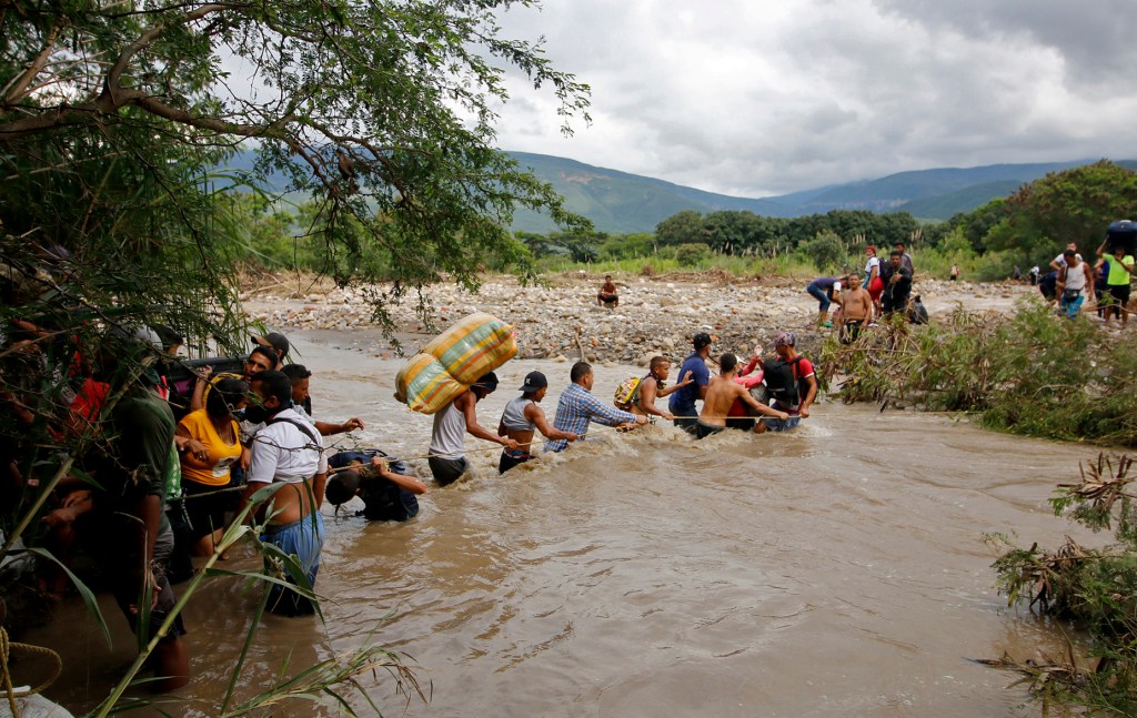 Migrants use a rope to cross the Tachira river between Colombia and Venezuela on November 19, 2020.