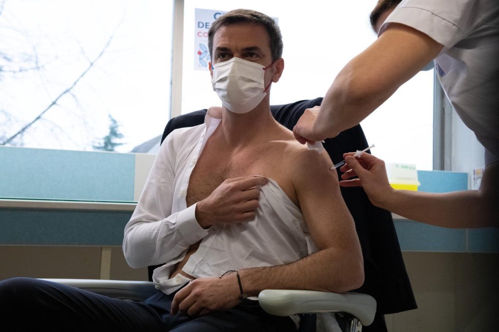 French Health Minister Olivier Veran covering his nipple with half a shirt as he gets vaccinated.