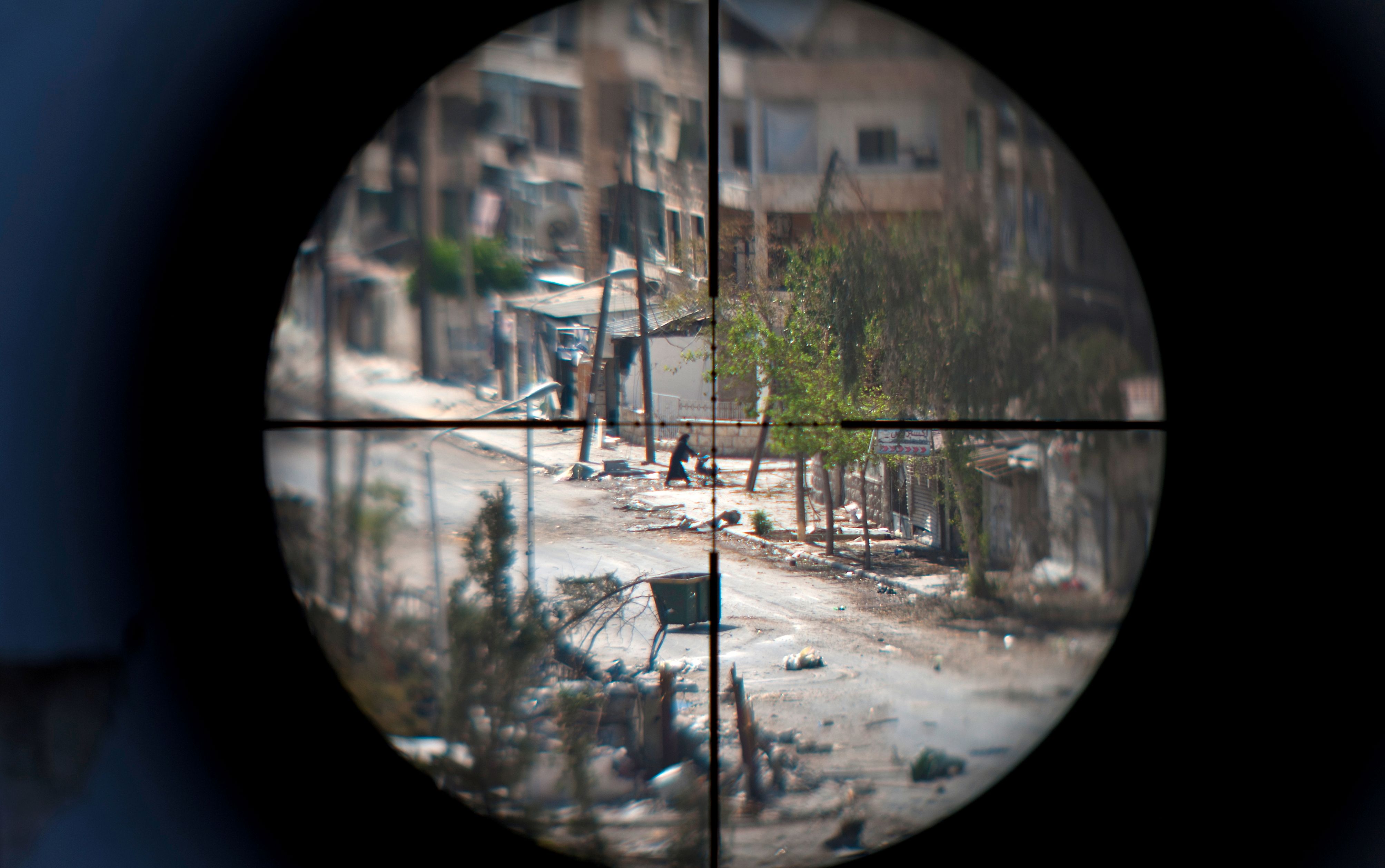 A woman and her baby as seen through the scope of an opposition fighter sniper gun, in Aleppo in August 2012. Photo: ZAC BAILLIE/AFP via Getty Images