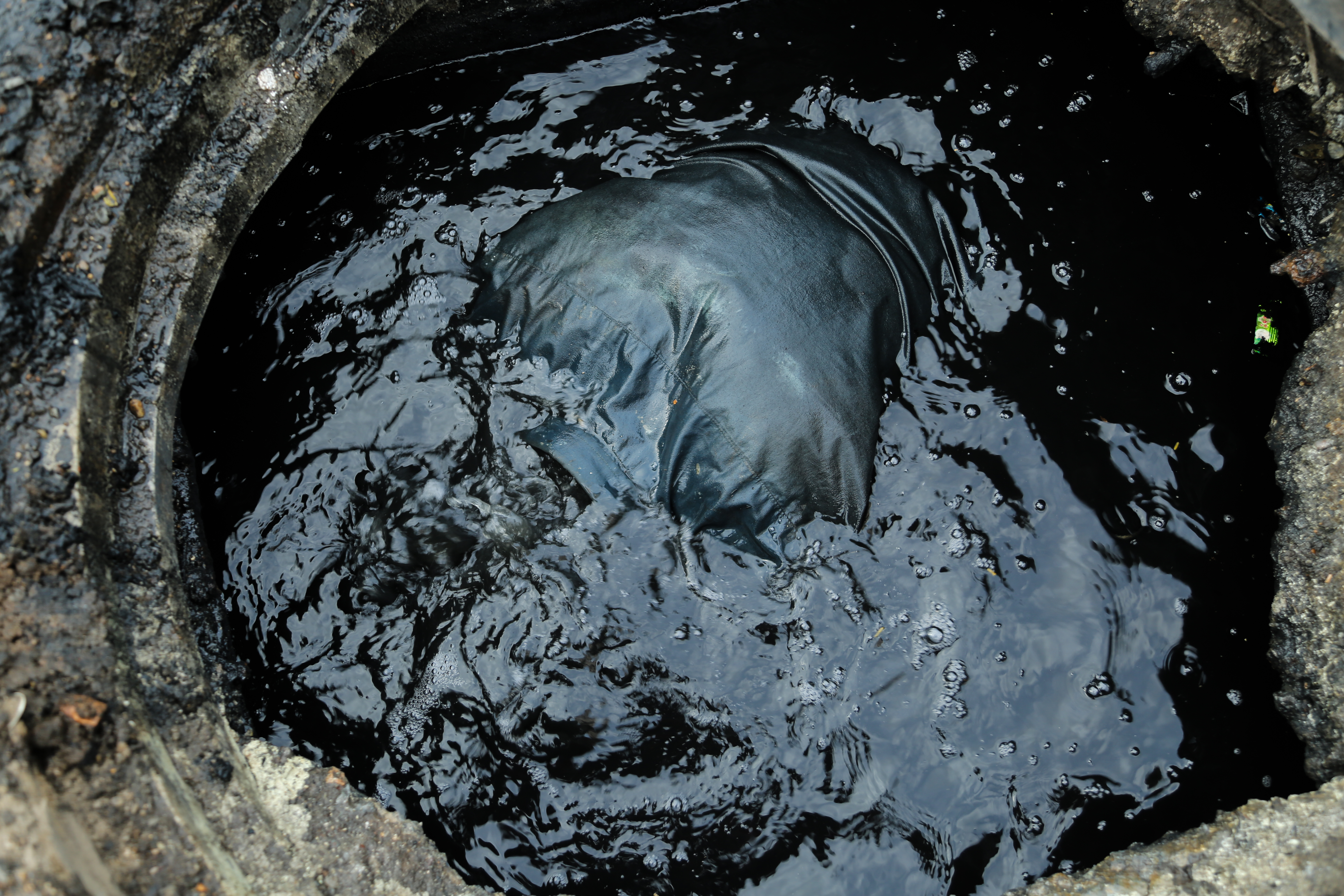 manual scavenging man in a sewage tank