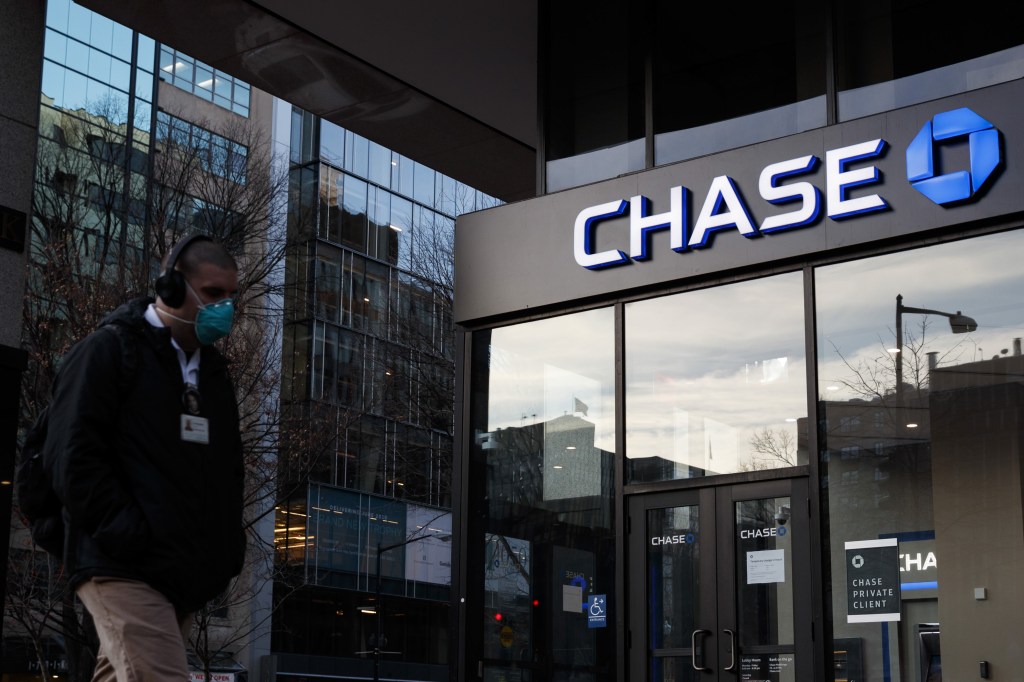 Pedestrians wearing protective masks walk past a JPMorgan Chase & Co. bank branch in New York, U.S., on Thursday, July 9, 2020.