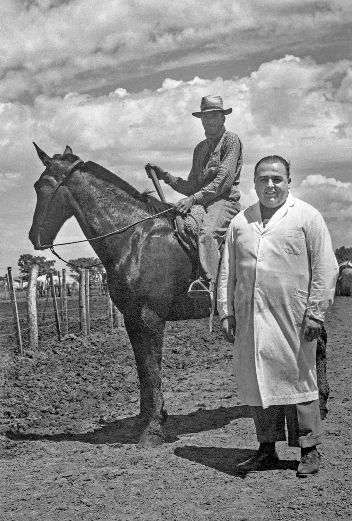 Un uomo in grembiule bianco davanti un uomo a cavallo