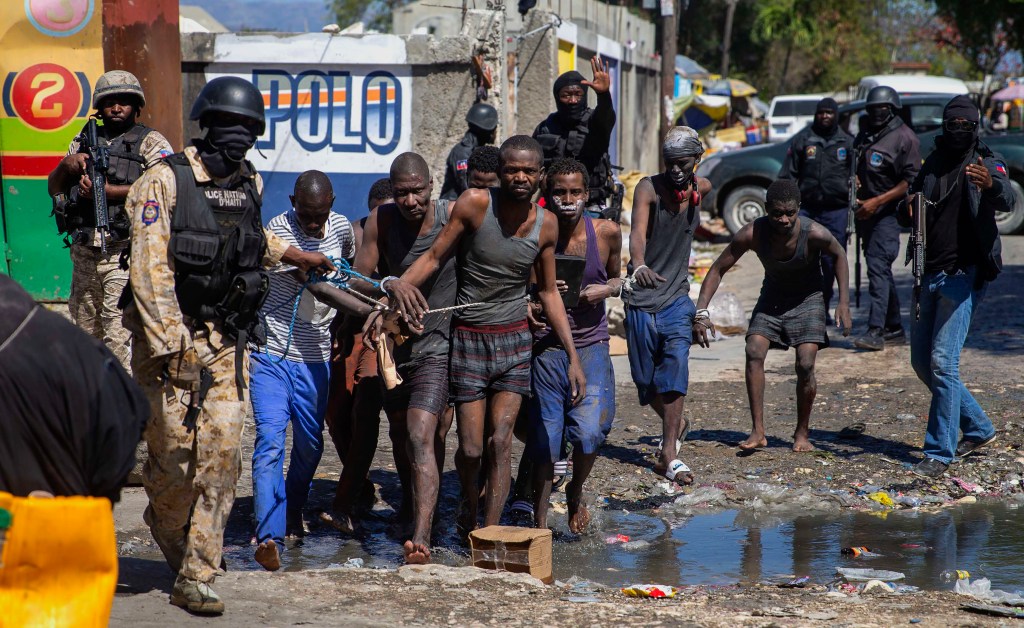 Recaptured inmates are led by police outside the Croix-des-Bouquets Civil Prison after an attempted breakout, in Port-au-Prince, Haiti