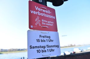 Ein rotes Schild zeigt an, dass man wegen der Corona-Pandemie in einem bestimmten Bereich nicht verweilen darf