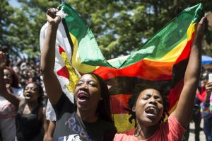 Women holding a flag of Zimbabwe take part in a demonstration of University of Zimbabwe's students, on November 20, 2017​.