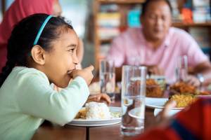 girl eating rice with hands